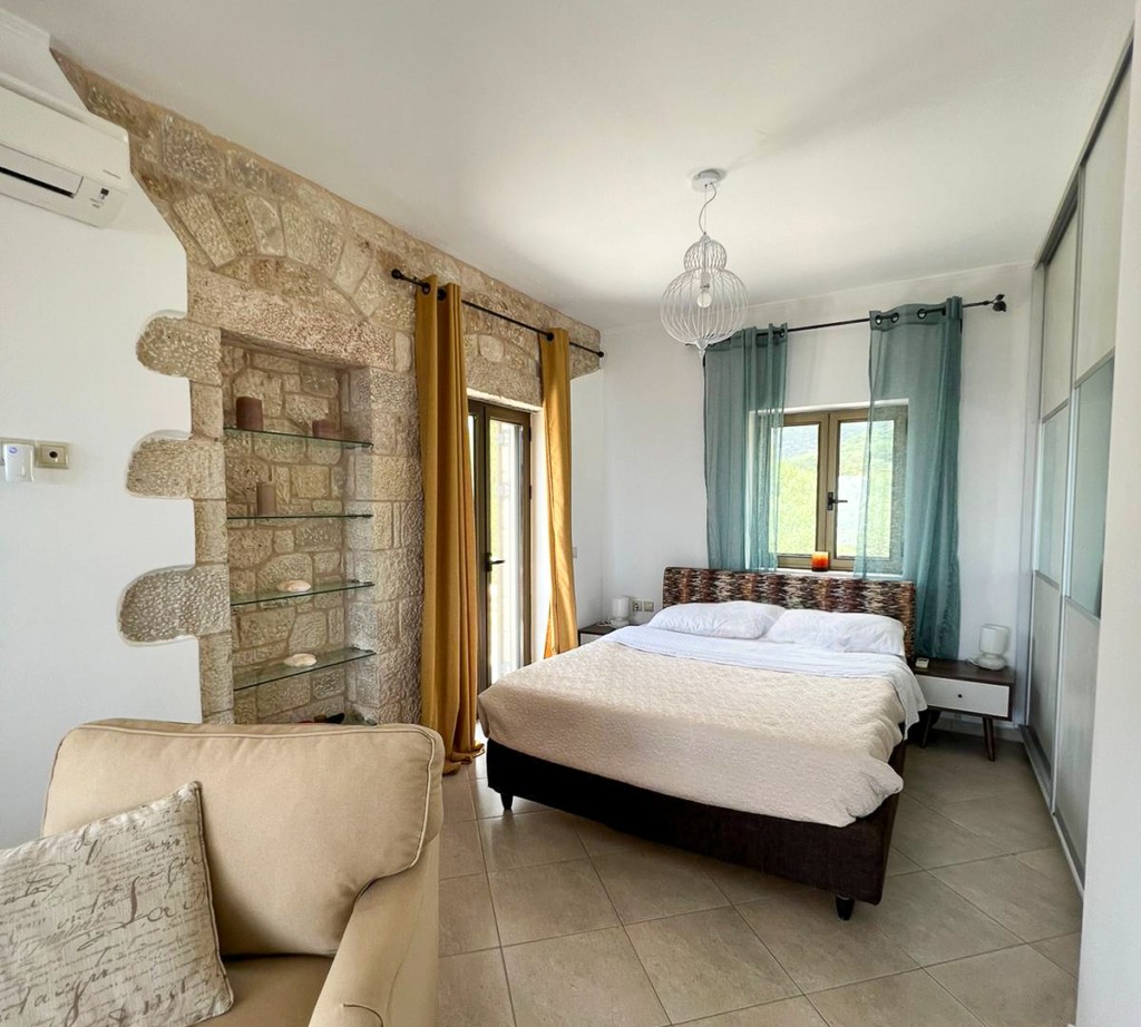 Cozy bedroom in Villa Leonidas with luxurious bedding and classic Greek interior.