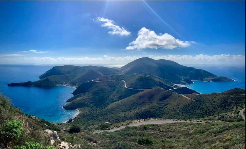 Panoramic view of the Peloponnese coastline with winding roads, hills, and blue waters under a clear sky