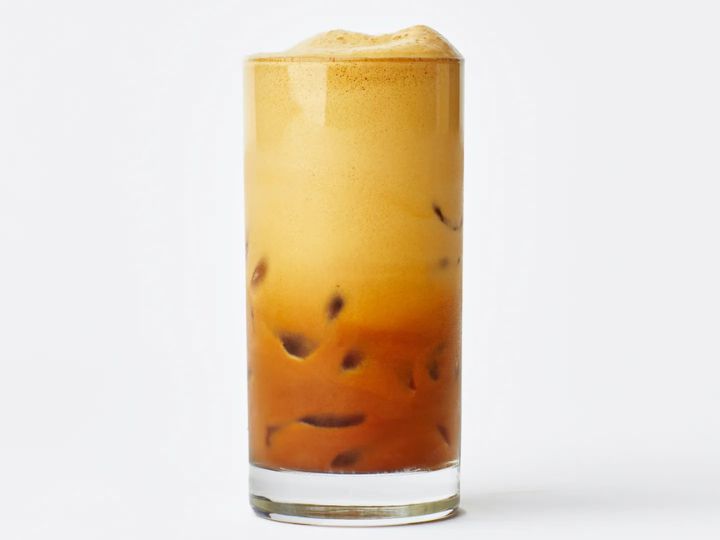Close-up of a classic Greek frappé iced coffee with foam and ice in a clear glass