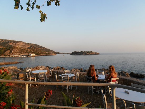 Two women enjoying dinner at Lela’s Taverna with a sea view at sunset in Kardamili, Greece