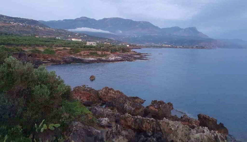 View of the rocky coastline and Taygetos mountains along the walking trail from Stoupa to Agios Nikolaos in Mani, Greece