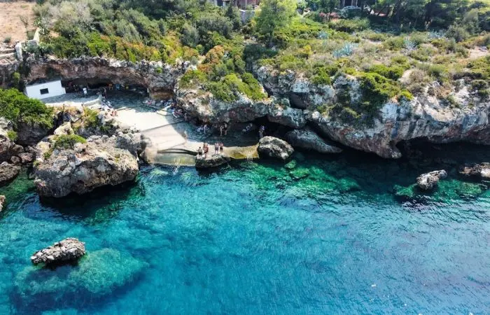 Aerial view of Gnospi Beach in Kardamyli, Greece with crystal-clear water and rocky cliffs