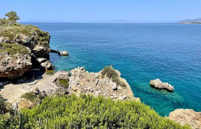 Elevated view of Gnospi swimming cove in Kardamyli with rocky cliffs and clear blue sea