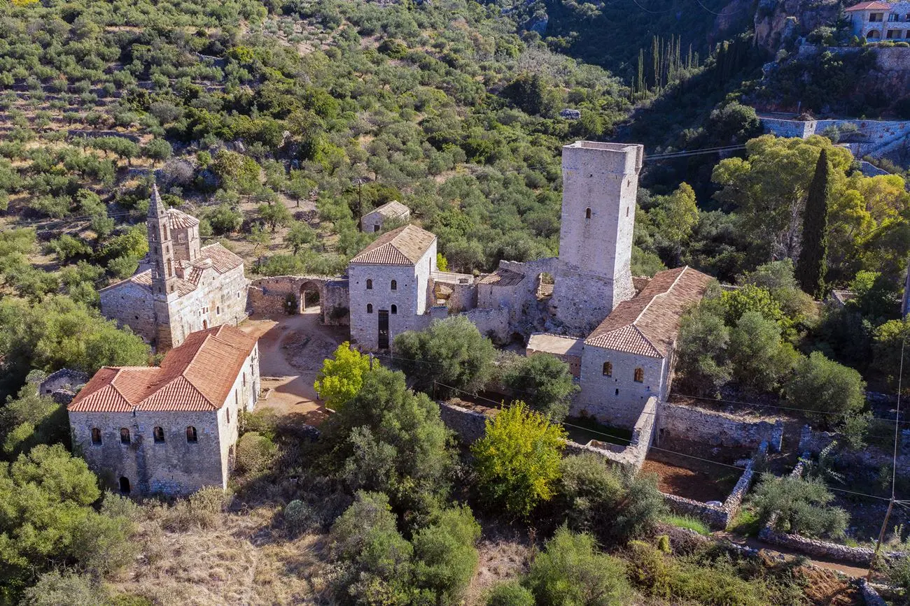 Aerial view of Mourtzinos Tower complex in old Kardamyli, surrounded by olive groves and Mani’s mountainous landscape