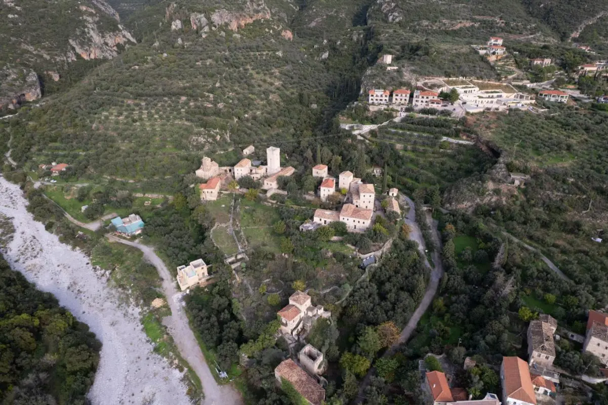 Aerial view of traditional stone tower houses in Old Kardamyli, showcasing the historic architecture surrounding luxury villas in Kardamili.