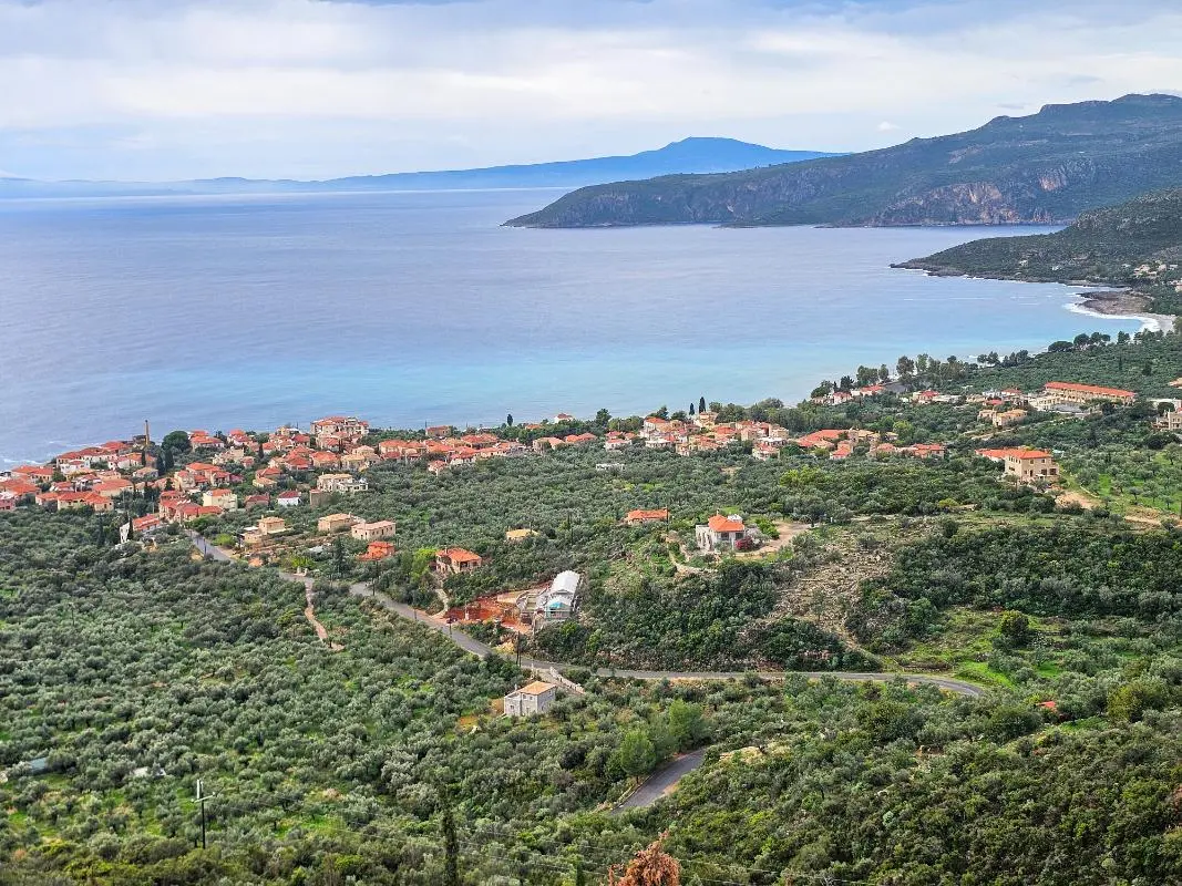 Scenic coastal view of Mani, Greece, featuring traditional stone architecture—the perfect destination to book luxury villas.