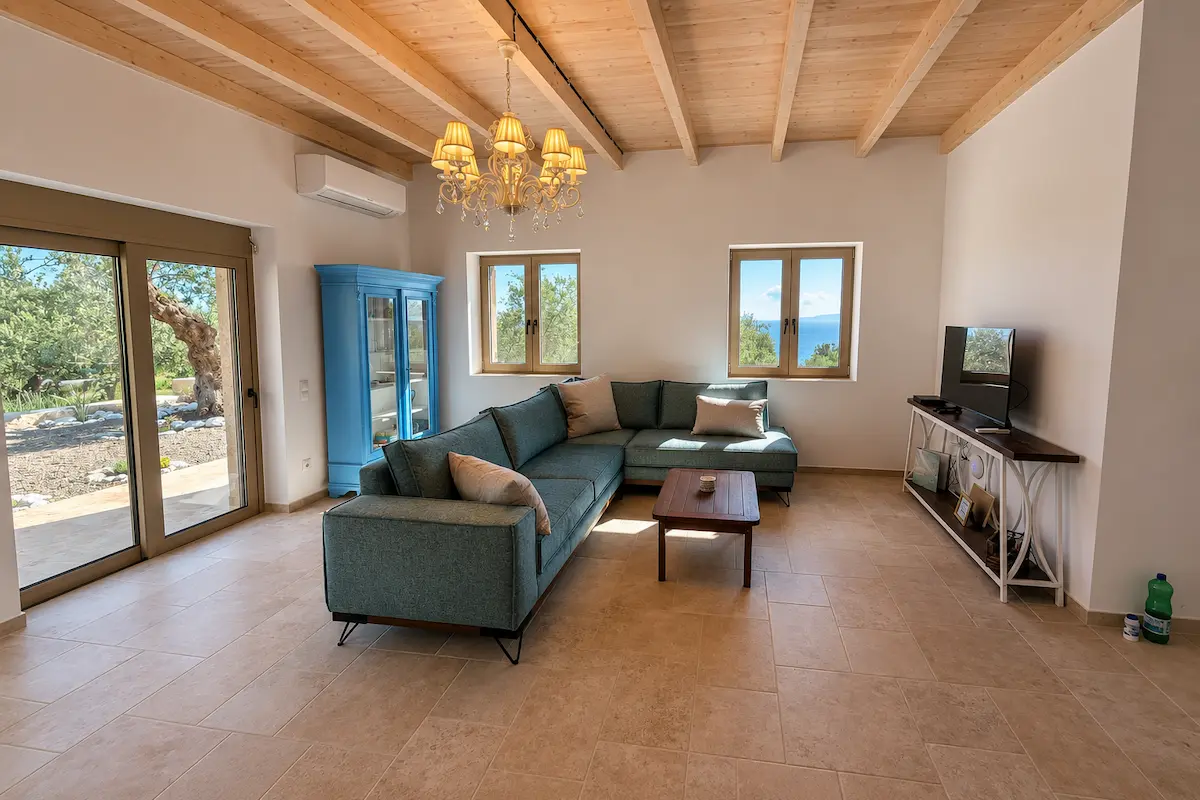 Bright coastal cottage living room with comfortable sofa, sea-view windows, and peaceful workspace atmosphere ideal for working remotely.