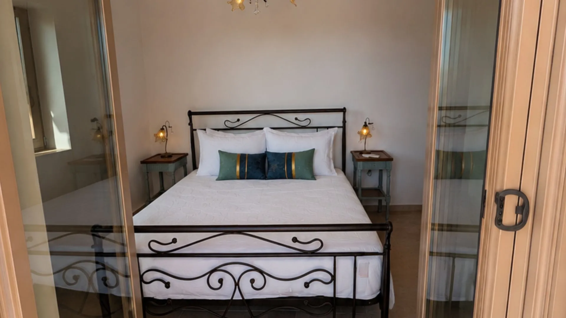 Achilles Cottage master bedroom with wrought iron bed in Kardamyli