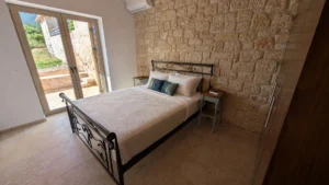 Bedroom at Achilles Cottage Kardamyli with Mani stone wall and terrace doors