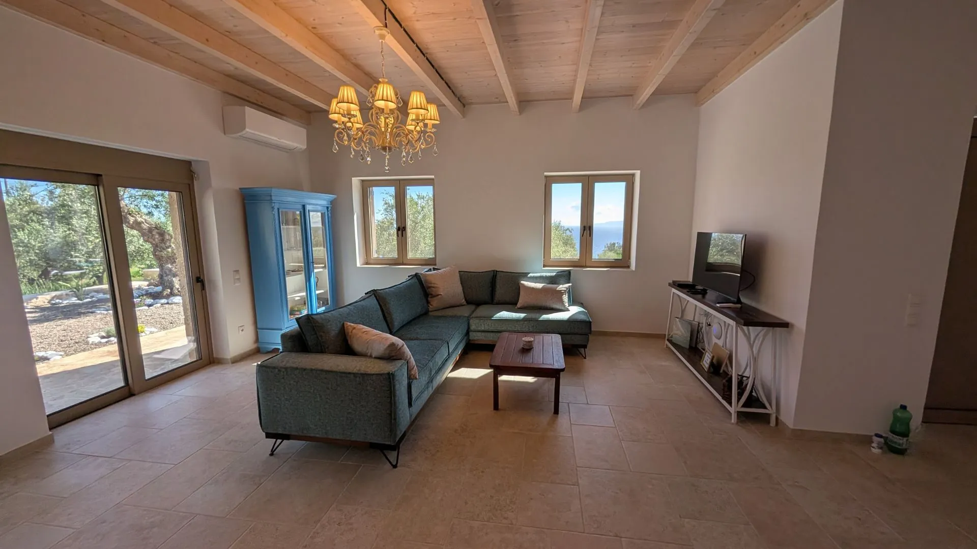 Achilles Cottage living room with sea view windows and brass chandelier