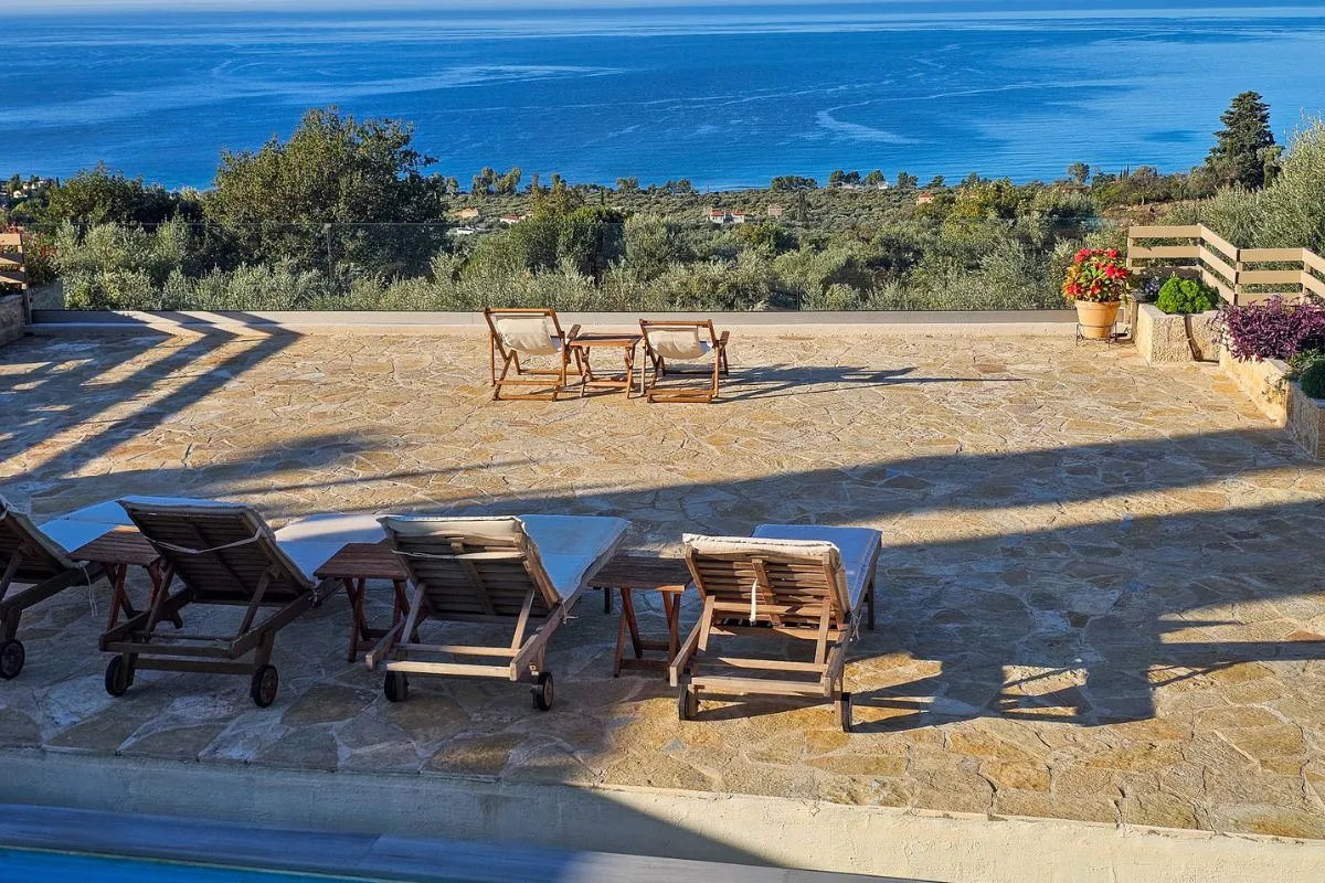 Villa Leonidas poolside lounge chairs overlooking the sea