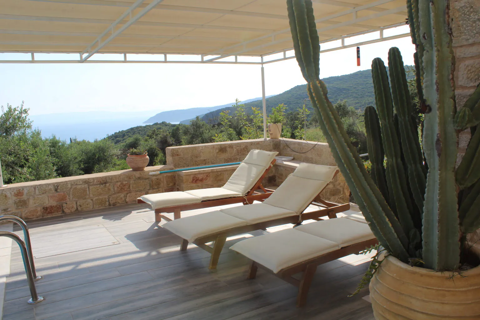 Mediterranean terrace overlooking ocean with sun loungers